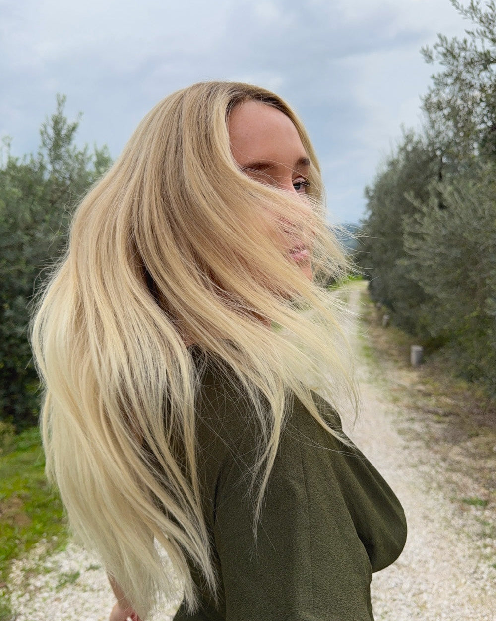 Woman wearing a BHBD Vera wig. Long wig in blonde with subtle golden tones and a naturally darker roots.