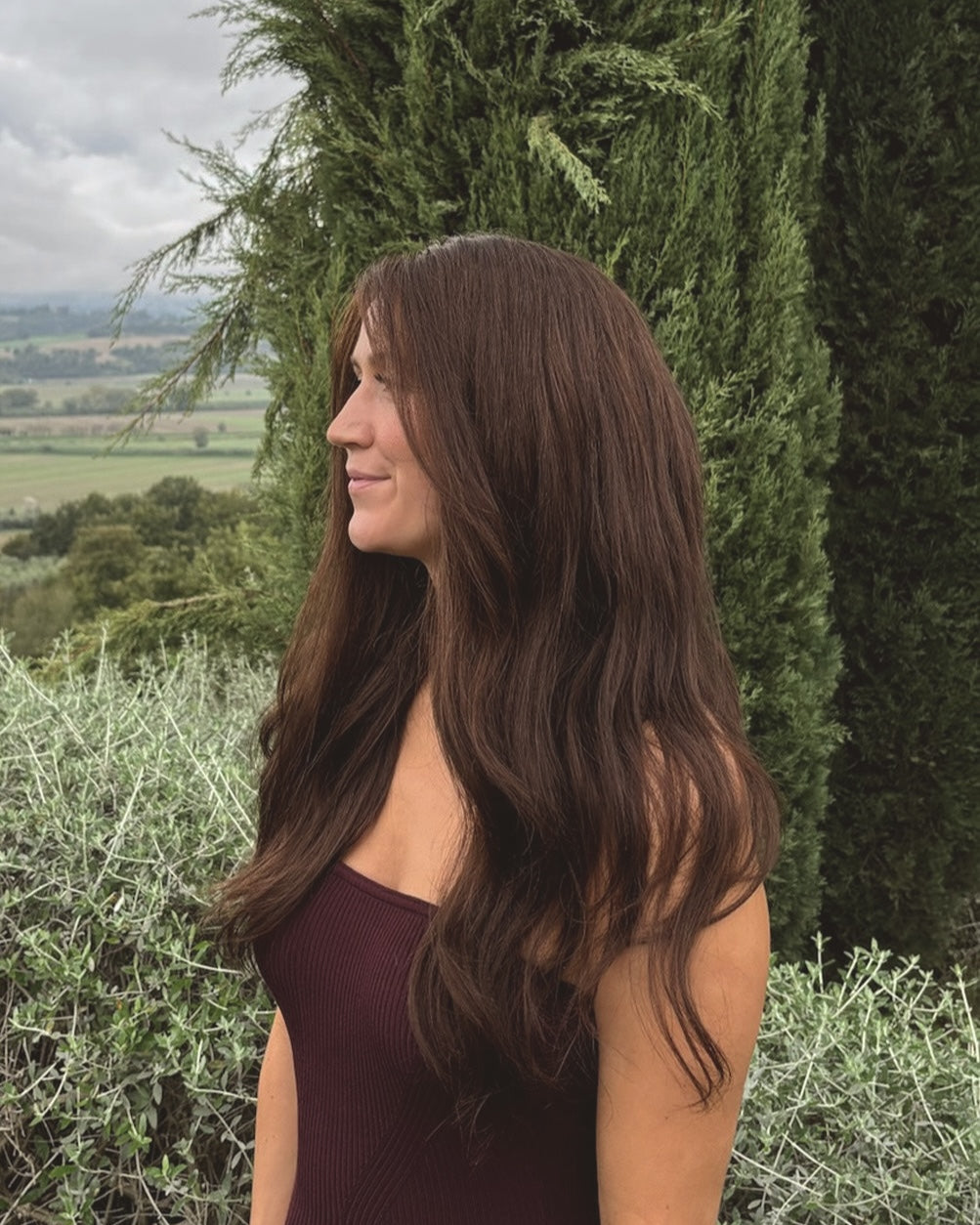 Woman wearing a BHBD Valentina wig. Long natural dark brown wig. 